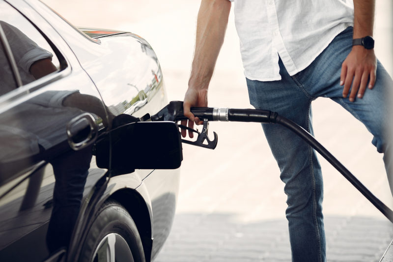 Handsome man pours gasoline into tank of car pompe a carburant diesel